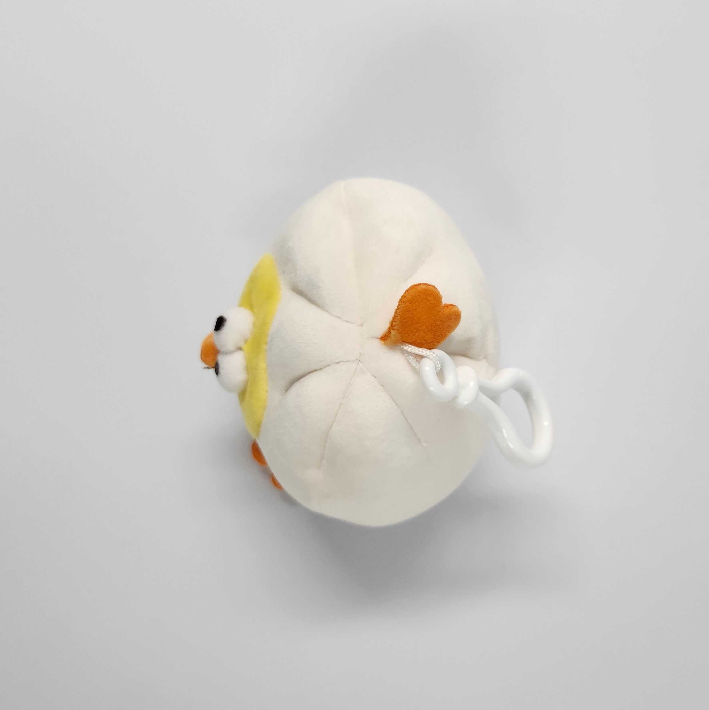 This is the top view of the mini plushie. The eyes and beak protrudes outwards, and the lobster clasp seems to be plastic with a white string holding the clasp. 