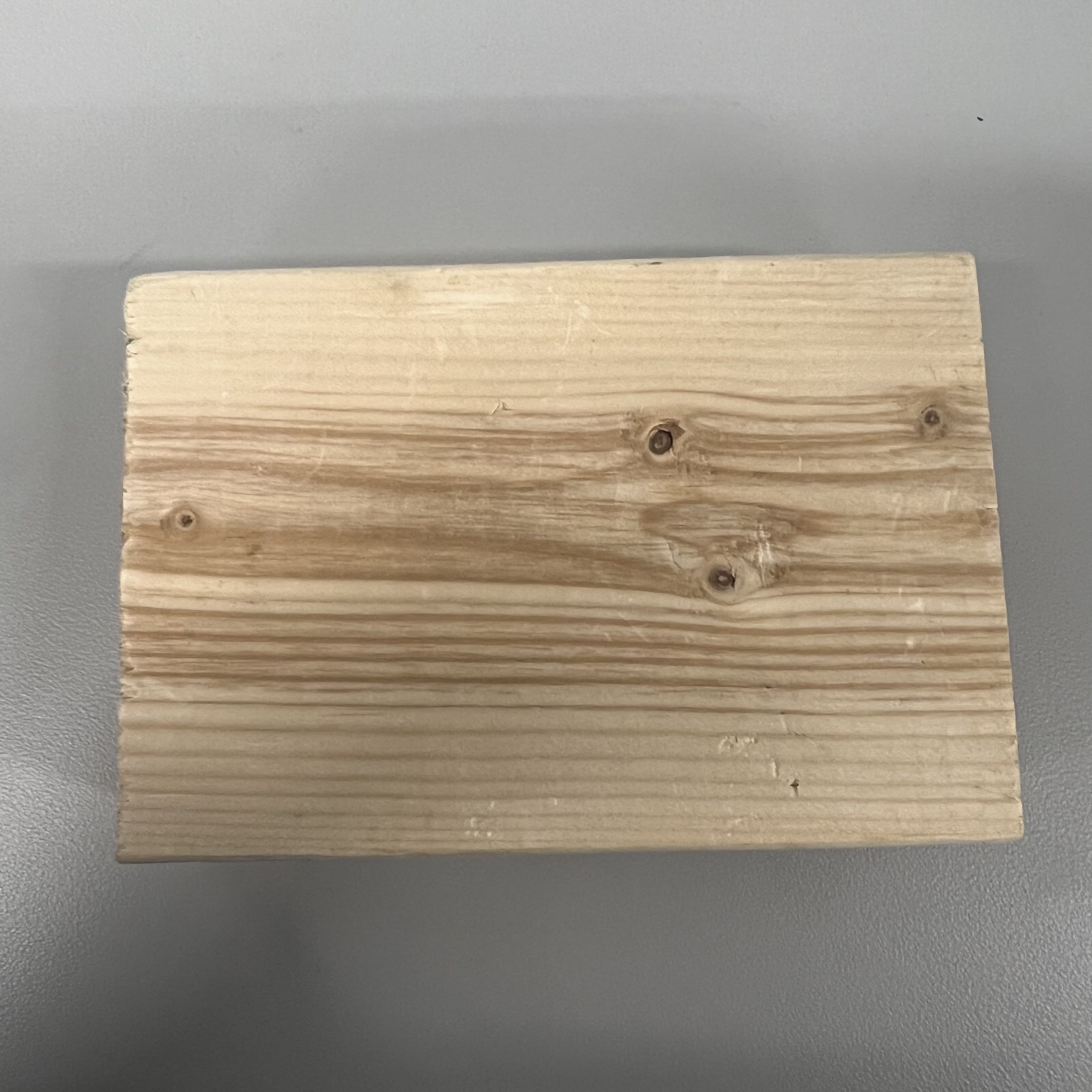 The material of this is wood, and the colour consists of light and dark brown. It's rigid, matte, and feels smooth. The block of wood is semi-refined, and can be used for frames, kitchenware, and furniture.